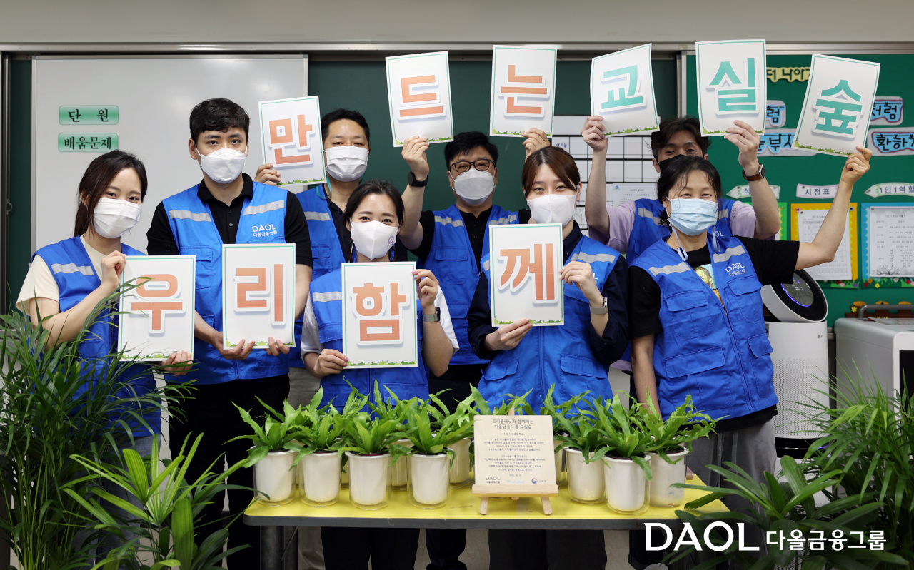 다올금융그룹 봉사단 ‘밝은내일 서포터즈’가 15일 수원 신성초등학교에서 ‘교실 숲’ 조성을 위한 공기정화식물을 전달하고 기념촬영을 하고 있다. [다올금융그룹 제공]
