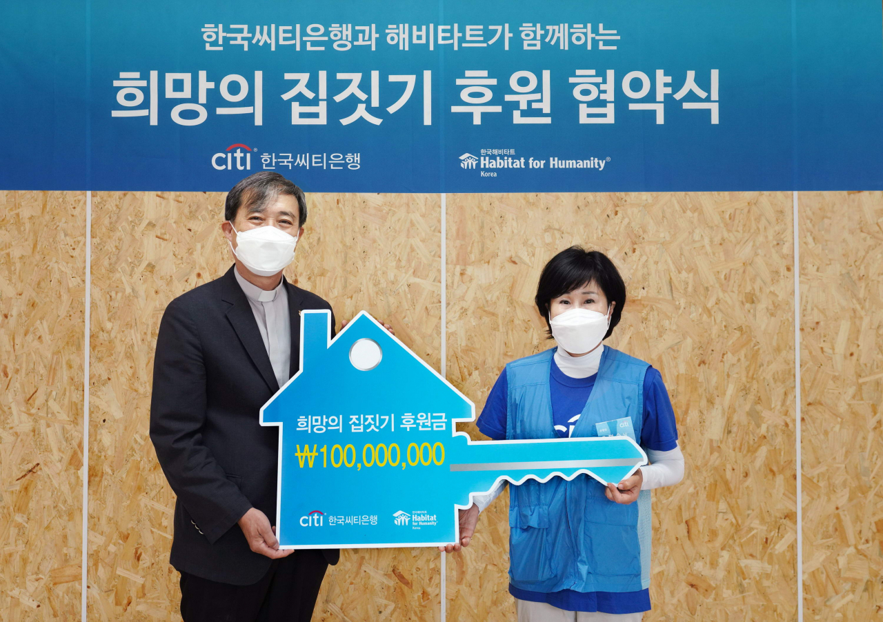 유명순 한국씨티은행장(오른쪽)이 충청남도 천안시 목천읍에 위치한 해비타트 건축 현장에서 희망의 집짓기 후원 협약식을 열고 윤마태 한국해비타트 충남세종지회 이사장에게 후원금 1억원을 전달하고 있다.[한국씨티은행 제공]