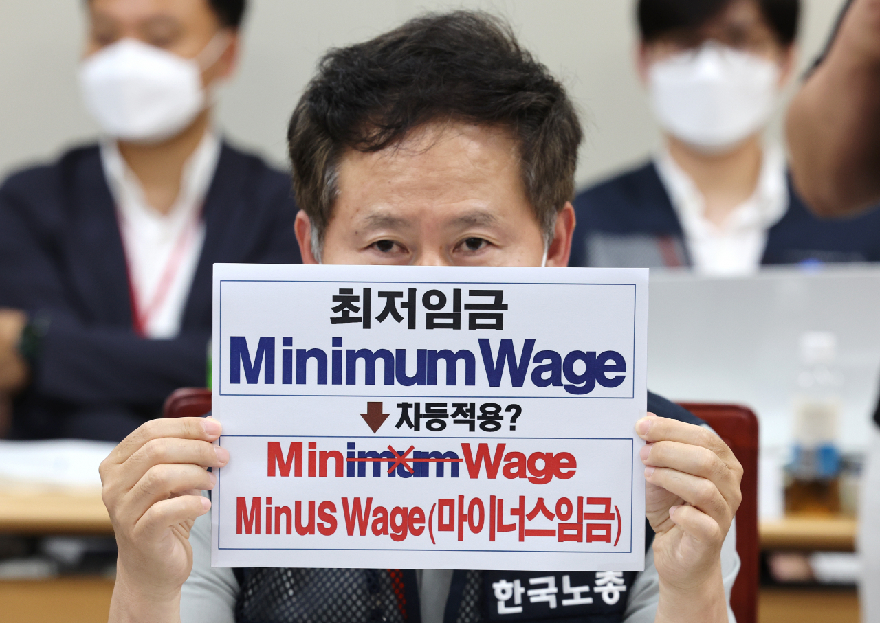 근로자위원인 정문주 한국노동조합총연맹(한국노총) 정책본부장이 지난 16일 오후 세종시 정부세종청사 최저임금위원회 회의실에서 열린 제4차 전원회의에서 최저임금 차등적용과 관련한 손팻말을 들어보이고 있다. [연합]