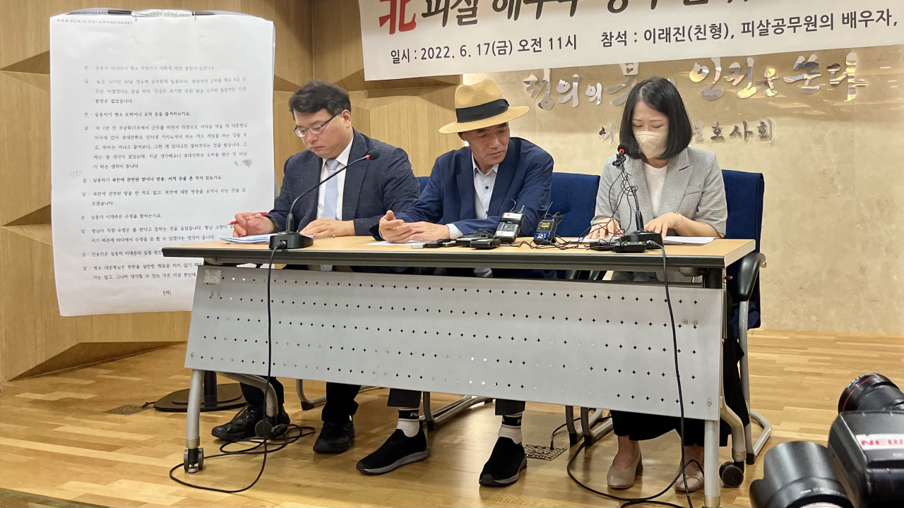 The family of the South Korean official who was shot dead by North Korean troops in 2020 on Friday criticized the Moon administration for “characterizing the deceased as a defector” without evidence. From left, attorney-at-law Kim Ki-yun, the official’s older brother Lee Rae-jin, and his widowed wife Kwon Young-mi. (Kim Arin/The Korea Herald)