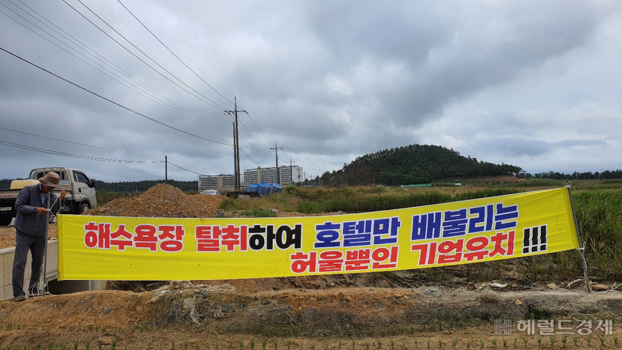 백길해수욕장 인근마을 주민들이 게시한 항의 현수막이 18일 오전 훼손된 채 버려지는 사건이 발생했다. 현수막을 뒤로 라마다&씨원리조트가 보인다. 서인주 기자