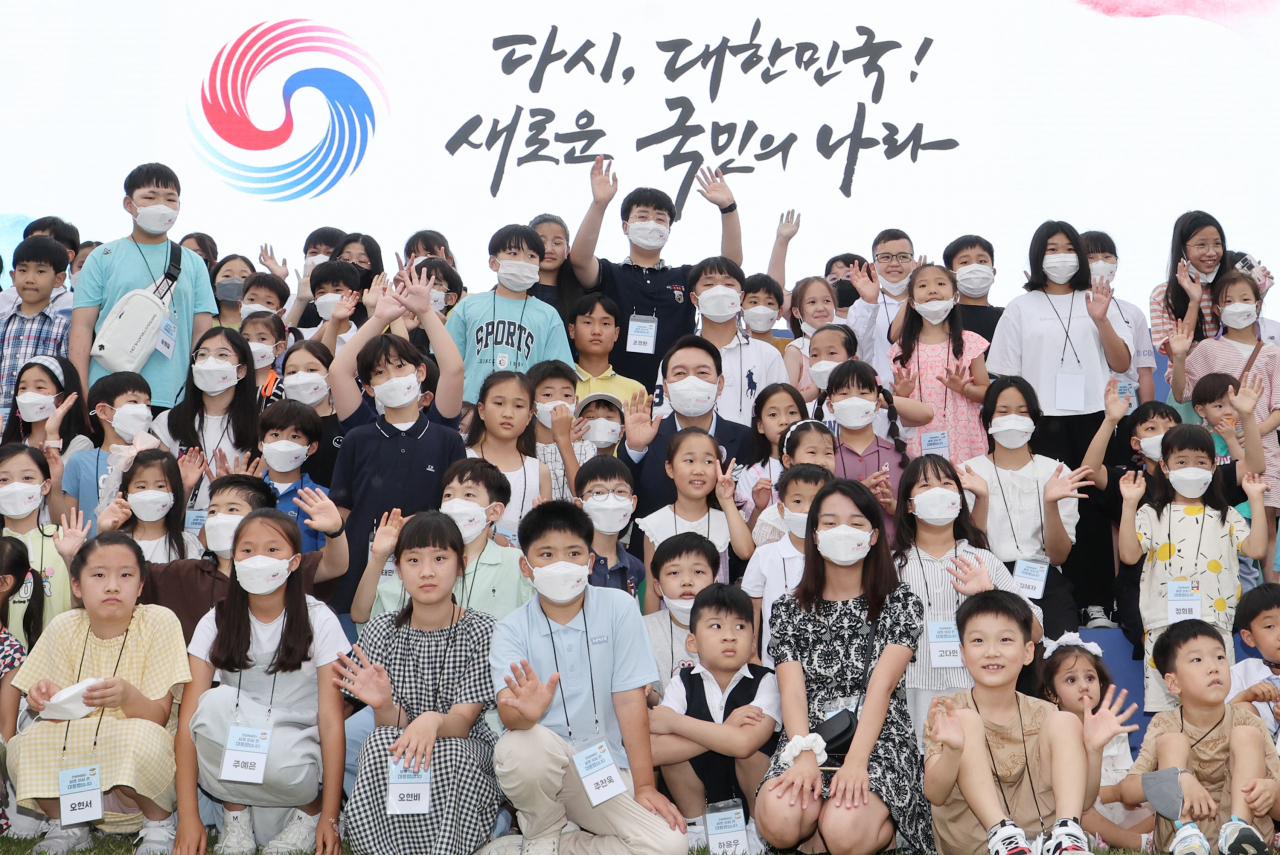 윤석열 대통령이 19일 오후 용산 대통령실 청사 앞 잔디광장에서 열린 대통령실 이전 기념 주민 초대 행사에서 어린이들과 기념촬영을 하고 있다. 연합뉴스