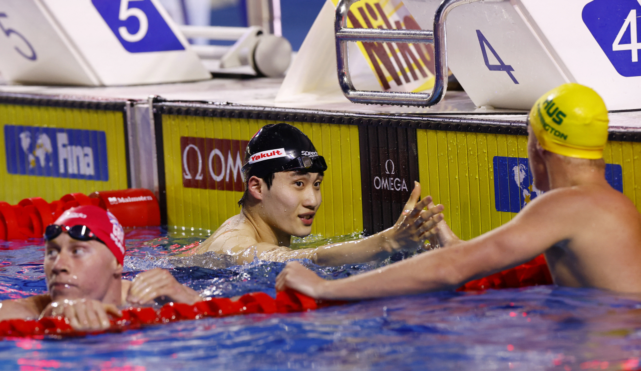 황선우(가운데)가 200m 준결승에서 1위로 골인한 뒤 축하를 받고 있다./로이터