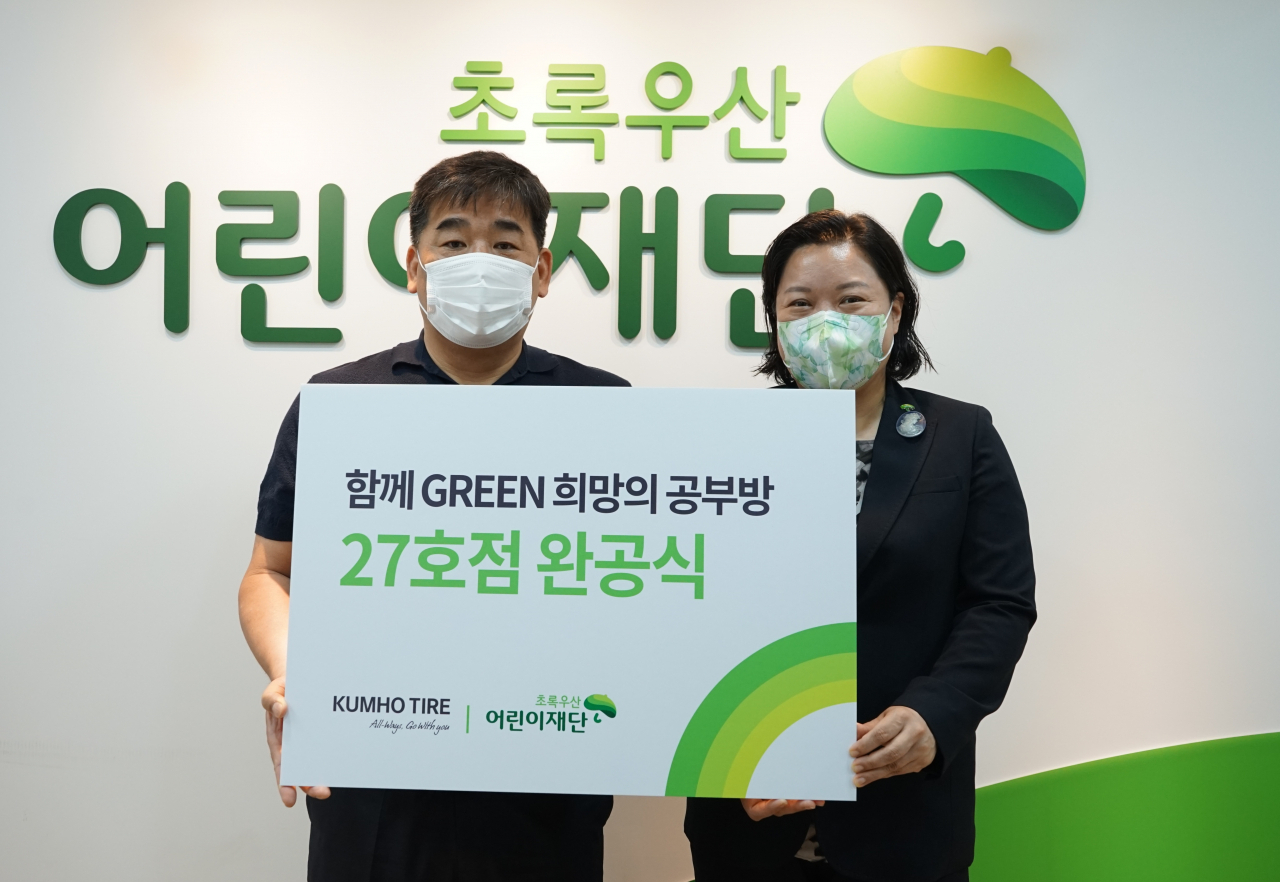 희망의 공부방 27호점 완공식에서 강진구(왼쪽) 금호타이어 경영지원팀장과 최운정 초록우산어린이재단 서울2지역본부장이 기념촬영을 하고 있다. [금호타이어 제공]