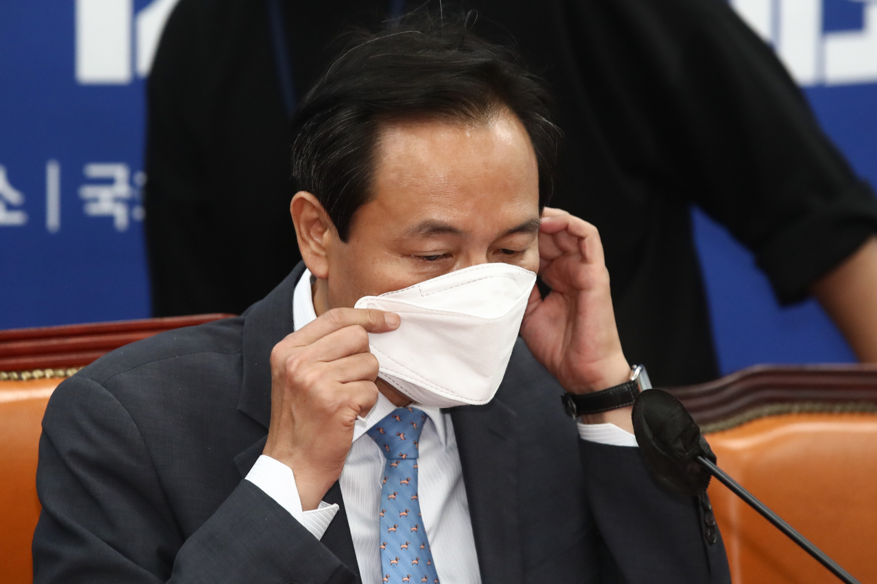 더불어민주당 우상호 비상대책위원장이 21일 국회에서 열린 민생우선실천단 제1차 전체회의에서 마스크를 고쳐쓰고 있다. [연합]