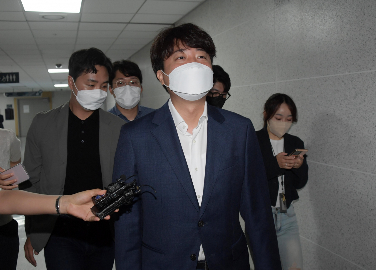 People Power Party Chairman Lee Jun-seok listens to reporters' questions as he leaves a seminar room at the National Assembly in Seoul on Tuesday. (Yonhap)