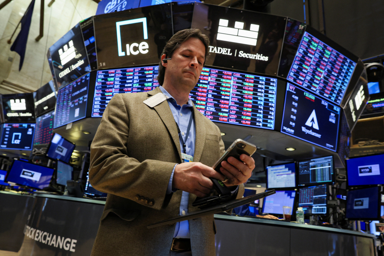 미 뉴욕증권거래소(NYSE)에서 트레이더가 휴대폰을 바라보고 있다. [로이터]