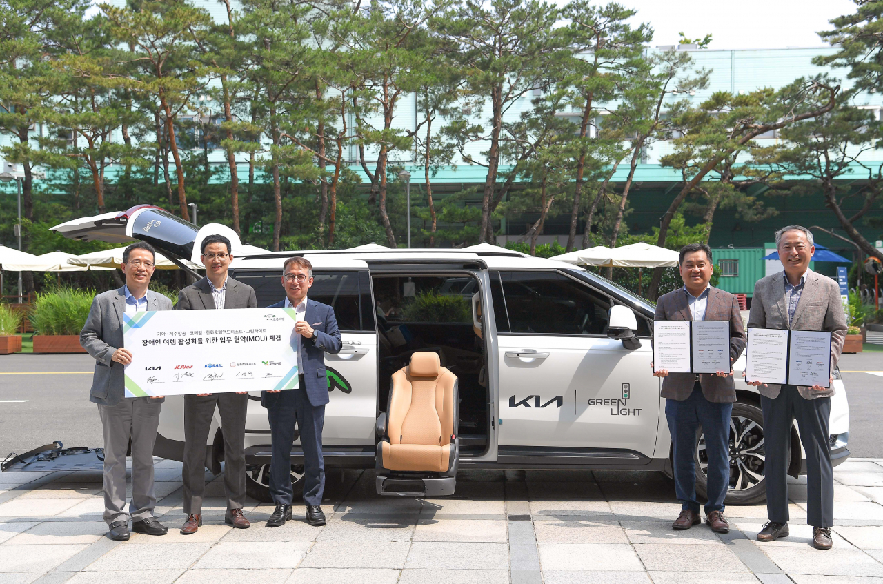 이덕현(왼쪽부터) 기아 경영전략실장, 김경원 제주항공 커머셜전략실장, 원종철 코레일 미래전략실장, 이상혁 한화호텔앤드리조트 HR그룹장, 김춘만 사단법인 그린라이트 이사가 ‘초록여행’ 장애인 전용 차량 앞에서 기념촬영을 하고 있다. [기아 제공]