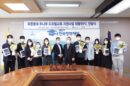 지난 22일 한국장학재단 서울사무소에서 진행된 ‘푸른등대 두나무 디지털교육 지원사업 태블릿PC 전달식’에서 이석우 두나무 대표이사(왼쪽 여섯번째)와 정대화 한국장학재단 이사장(왼쪽 일곱번째)이 장학생들에 디지털 기기를 전달하고 기념촬영을 하고 있다. [두나무 제공]