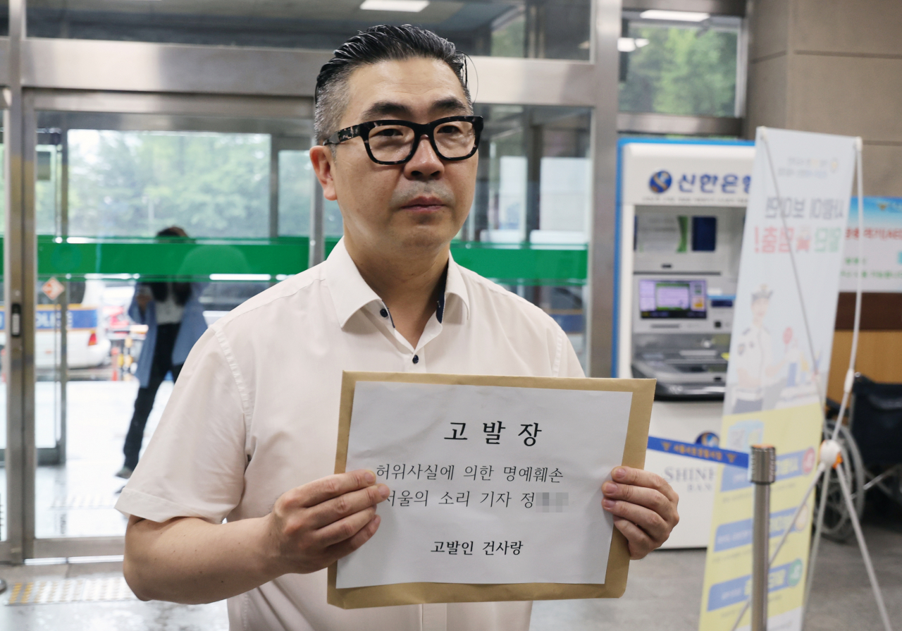 김건희 여사 팬카페인 '건사랑'의 이승환 대표가 23일 윤석열 대통령 서초동 자택 앞에서 맞불 집회를 벌여온 인터넷 언론사 '서울의소리'의 정 모 기자를 허위사실에 의한 명예훼손 혐의로 서울 서초경찰서에 고발하고 있다. [연합]