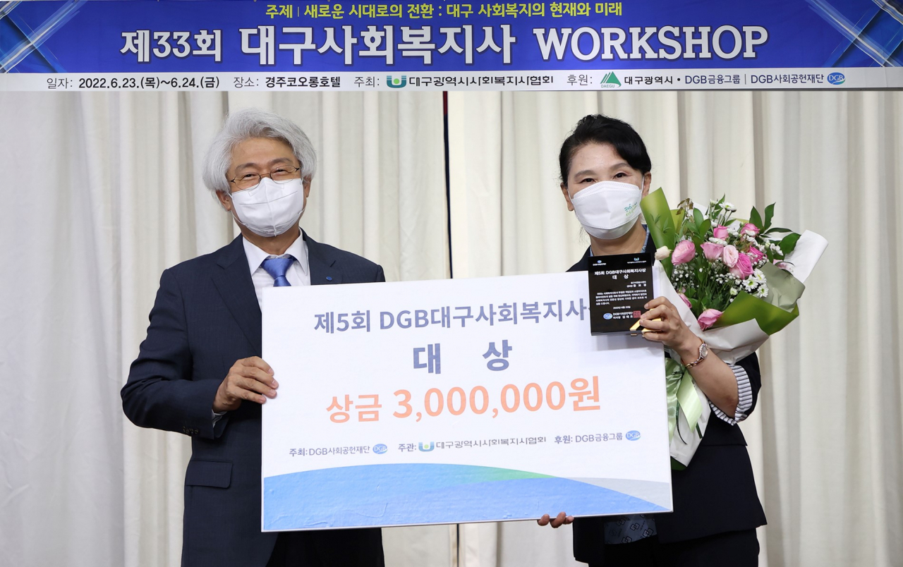 김태오 DGB금융그룹 회장(왼쪽)과 윤보경 대구중구자원봉사센터장이 23일 경주 코오롱호텔에서 개최된 ‘제33회 대구사회복지사 워크숍’에서 ‘제5회 DGB대구사회복지사 상’ 시상 이후 기념촬영을 하고 있다.[DGB금융그룹 제공]