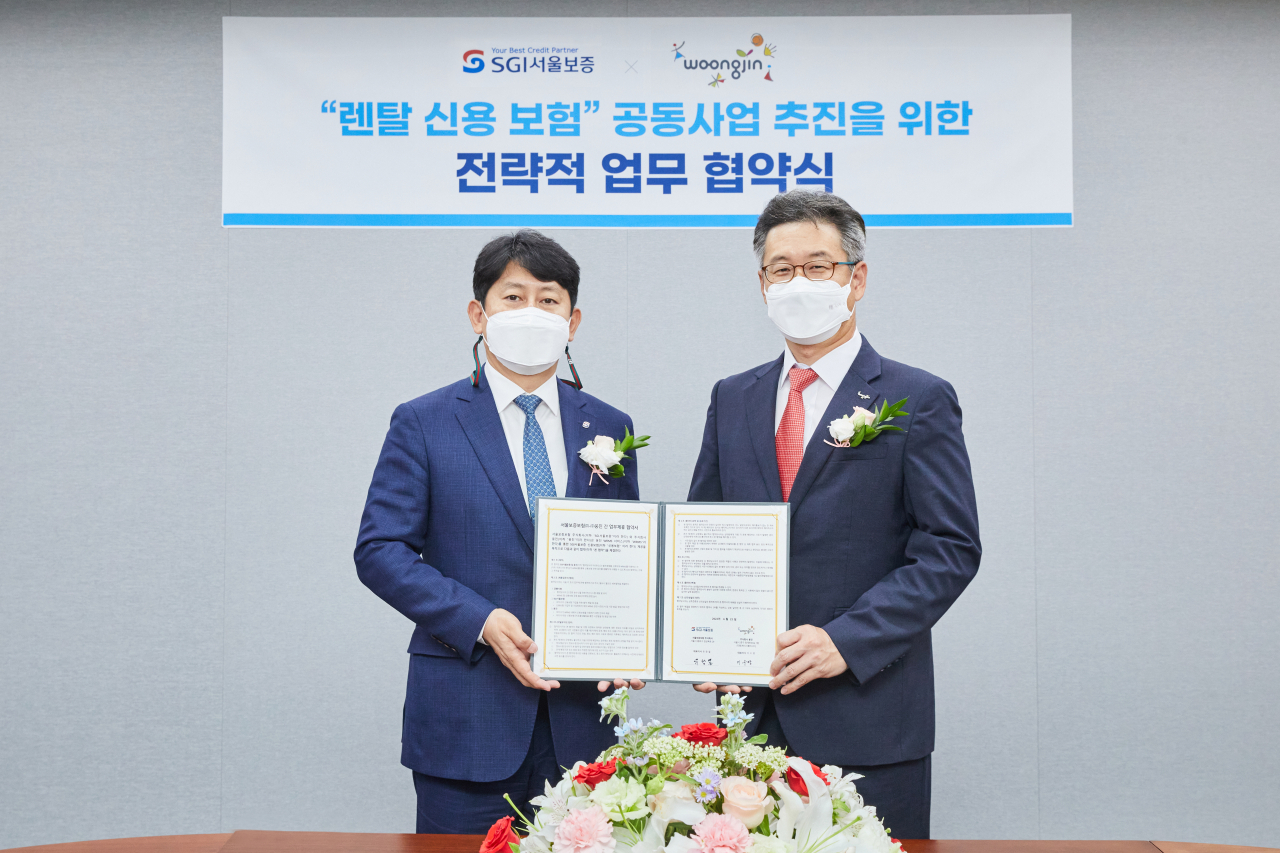[사진=유광열 SGI서울보증 대표(왼쪽)와 이수영 웅진 대표가 업무협약을 체결하고 있다.]