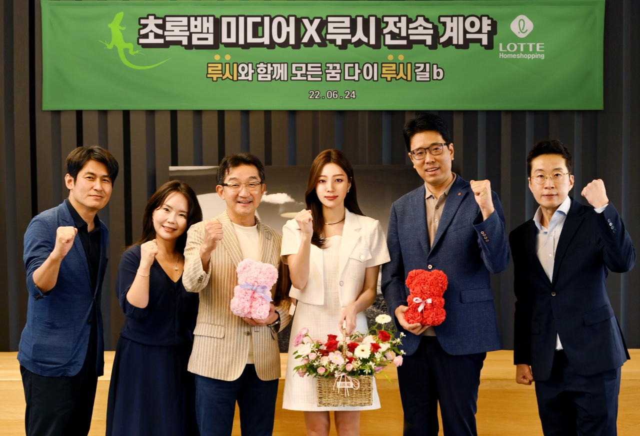 롯데홈쇼핑이 만든 가상인간 루시(왼쪽 네번째)가 지난 24일 서울 잠원동 초록뱀미디어 본사에서 콘텐츠 제작사 ‘초록뱀미디어’의 소속 아티스트로 전속 계약을 체결했다. [롯데홈쇼핑 제공]