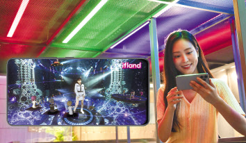 SKT는 메타버스 뮤직 페스티벌을 자사 플랫폼 이프랜드에서 개최한다고 27일 밝혔다. 모델이 스마트폰을 사용해 메타버스 뮤직 페스티벌을 감상 중이다. [SKT 제공]