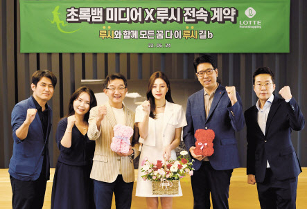 롯데홈쇼핑이 만든 가상인간 루시(왼쪽 네번째)가 지난 24일 서울 잠원동 초록뱀미디어 본사에서 콘텐츠 제작사 ‘초록뱀미디어’의 소속 아티스트로 전속 계약을 체결했다. [롯데홈쇼핑 제공]