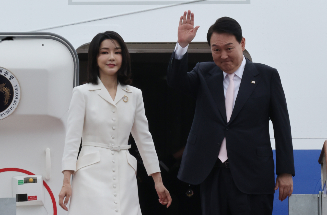 윤석열 대통령과 김건희 여사가 스페인 마드리드에서 열리는 북대서양조약기구(나토) 정상회의 참석을 위해 27일 경기 성남 서울공항에서 공군 1호기에 올라 인사하고 있다. [연합]