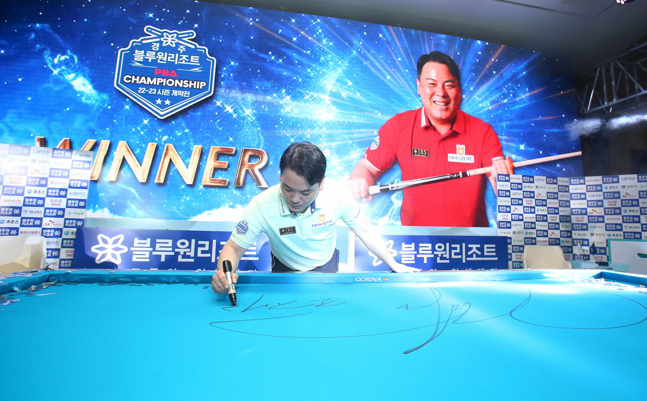 우승을 확정지은 조재호가 시상식에서 당구대에 자필 서명을 하고 있다. [PBA 제공]