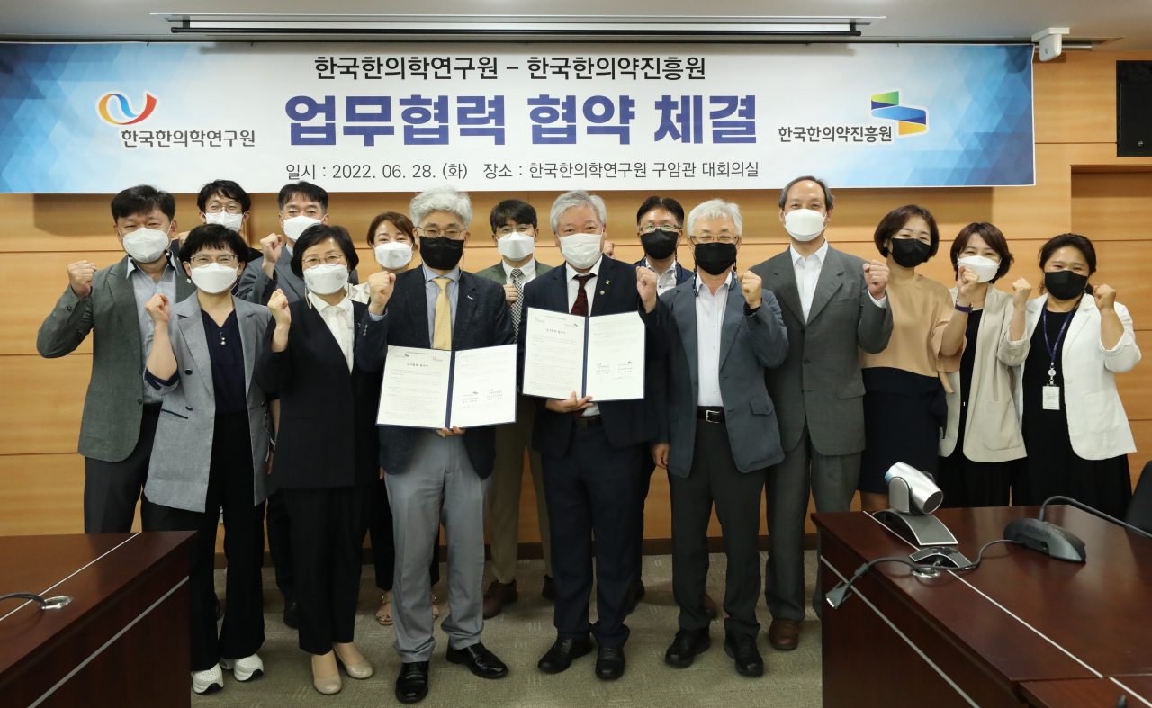 28일 열린 한국한의학연구원-한국한의약진흥원 업무협력 협약 체결식. 이진용(가운데 오른쪽) 한의학연 원장과 정창현 한의약진흥원 원장이 협약서를 들어보이고 있다.[한국한의학연구원 제공]