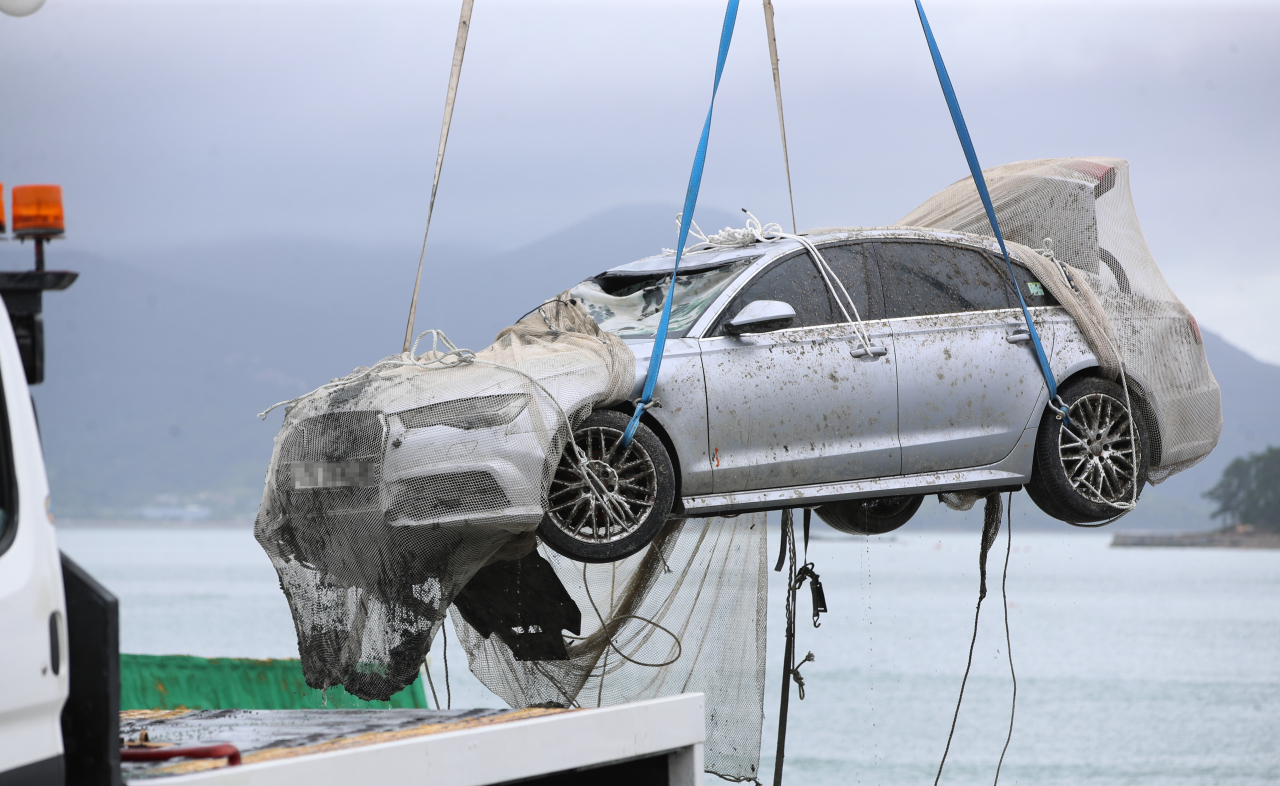 The police pulls a submerged car which belonged to Cho's family off the shores of Wando, South Jeolla Province, Wednesday. (Yonhap)