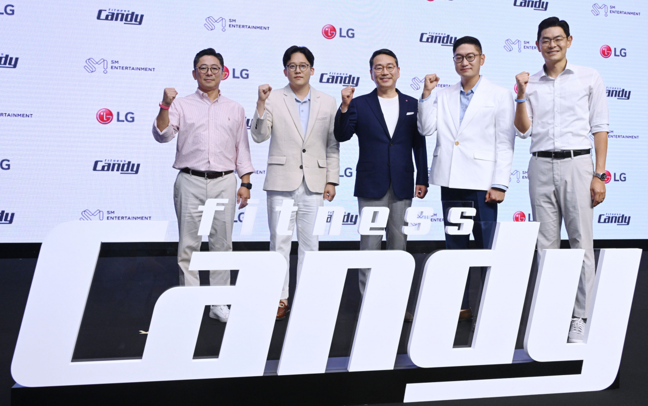30일 서울 여의도 콘래드호텔에서 SM엔터테인먼트와 홈 피트니스 분야 합작법인 ‘피트니스캔디(Fitness Candy)’ 출범식을 열고 사업 비전과 향후 계획을 발표했다. 심우택(왼쪽부터) 피트니스캔디 대표, 이성수 SM엔터테인먼트 공동대표, 조주완 LG전자 CEO 사장, 탁영준 SM엔터테인먼트 공동대표, 김비오 피트니스캔디 부대표.[LG전자 제공]