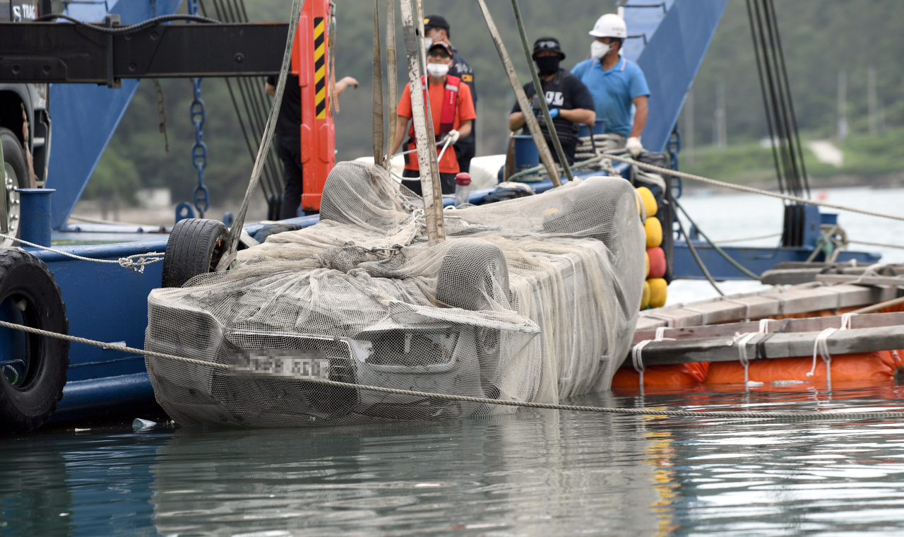 The police pulls a submerged car which belonged to Cho`s family off the shores of Wando, South Jeolla Province, Wednesday. (Yonhap)