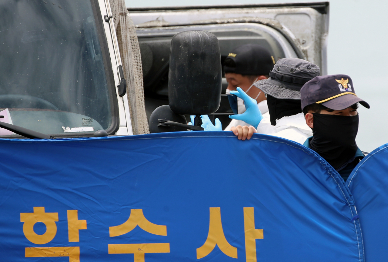29일 오전 전남 완도군 신지면 송곡선착장 인근 방파제에서 경찰이 10ｍ 바닷속에 잠겨있는 조유나(10)양 가족의 차량을 인양한 뒤 차량 내부를 촬영하고 있다. 경찰은 실종된 조양의 가족과 차량을 찾기 위해 수중 수색하다 전날 가두리양식장 아래에 잠겨있는 차량을 발견했다. [연합]