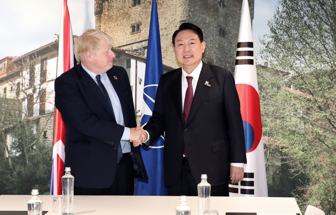 북대서양조약기구(NATO·나토) 정상회의 참석차 스페인 마드리드를 방문 중인 윤석열 대통령이 30일 오전(현지시간) 마드리드 이페마 컨벤션센터에서 보리스 존슨 영국 총리와 정상회담에 앞서 악수하고 있다. [연합]