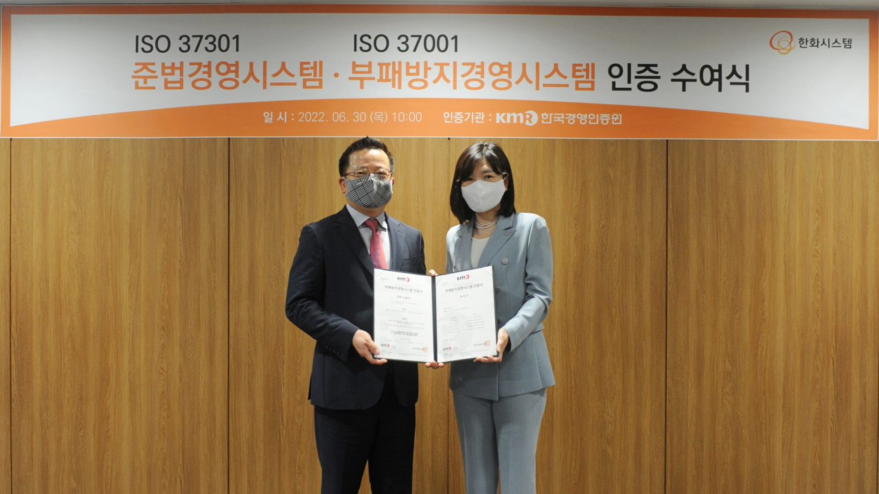 지난달 30일 어성철(왼쪽) 한화시스템 대표가 황은주 한국경영인증원 대표로부터 준법경영시스템 및 부패방지경영시스템 인증서를 받은 뒤 기념사진을 찍고 있다. [한화시스템 제공]
