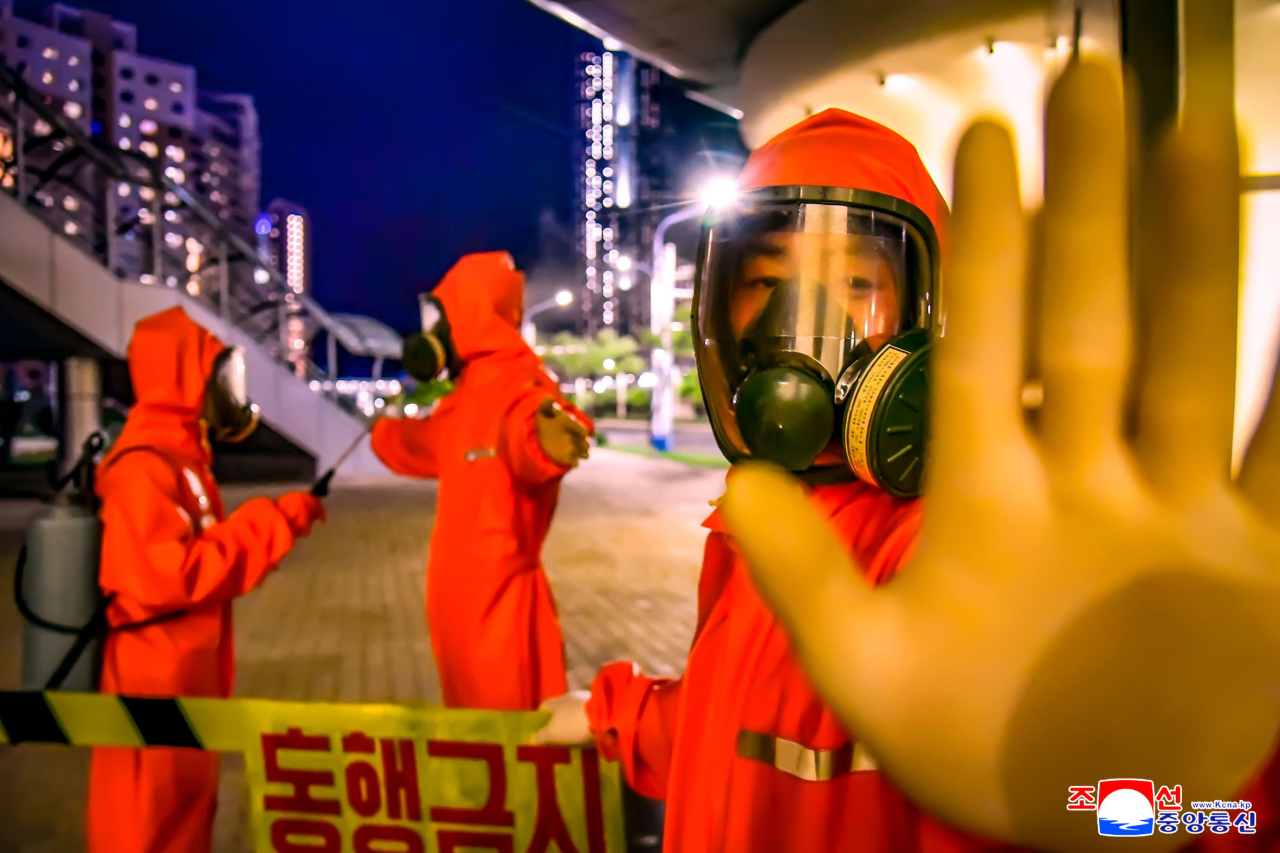 This photo, released by North Korea's official Korean Central News Agency on June 7, 2022, shows workers sanitizing the capital city of Pyongyang. (Yonhap)