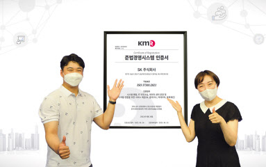 SK㈜ C&C 관계자가 한국경영인증원으로부터 획득한 국제표준화기구 준법경영시스템 인증서를 선보이고 있다. [SK㈜ C&C 제공]
