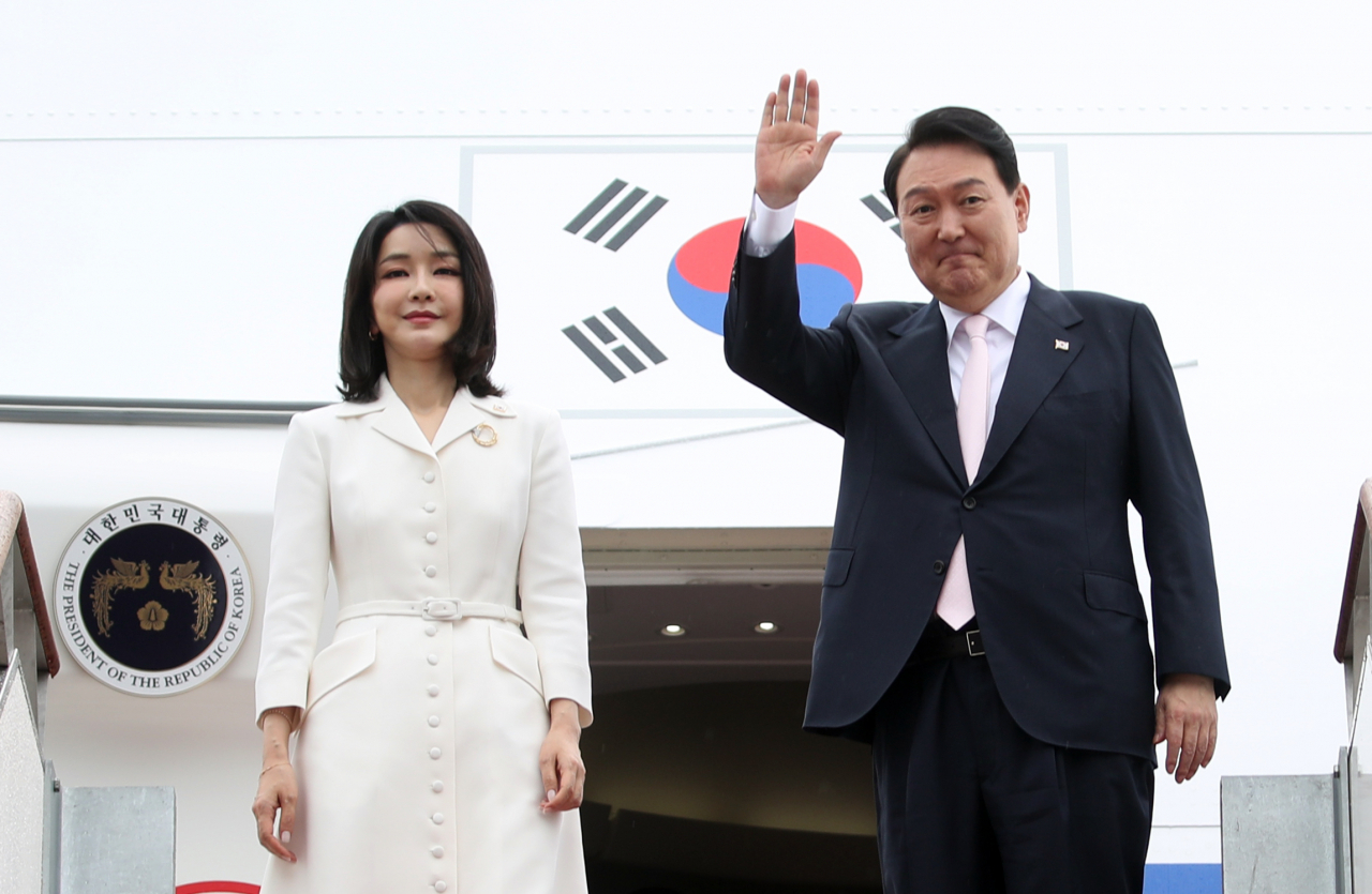 윤석열 대통령과 김건희 여사가 스페인 마드리드에서 열리는 북대서양조약기구(나토) 정상회의 참석을 위해 27일 경기 성남 서울공항에서 공군 1호기에 올라 인사하고 있다. [연합]