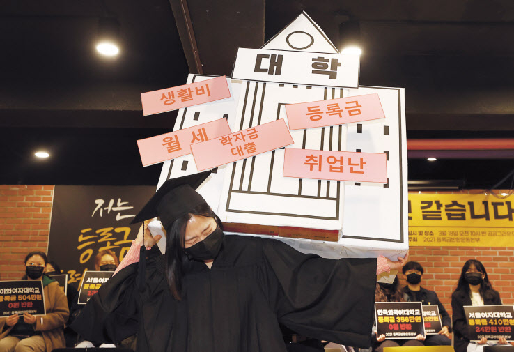 지난해 대학로 공공그라운드에서 2021등록금반환운동본부 주최로 열린 ‘코로나 대학생 피해사례 증언대회’에서 참가자들이 대학생이 겪고있는 어려움을 표현하는 퍼포먼스를 하고 있다. 이들은 ‘코로나19 2년째인 올해 대학과 정부는 등록금 반환에 대한 논의를 진행하지 않고 있으며, 최악의 실업난과 구직난에 시달리는 학생들의 생활고를 외면하고 있다’고 주장했다. [연합]
