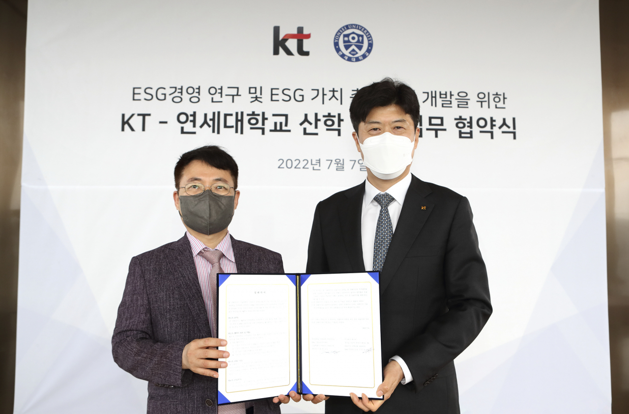KT ESG경영추진실장 김무성 상무(오른쪽)와 연세대 ESG/기업윤리 연구센터장 이호영 교수가 ESG 가치 측정 모델 개발을 위해 협약을 체결하고 기념촬영을 하고 있다. [KT 제공]