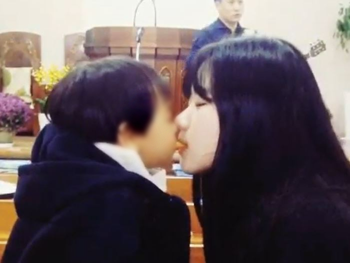 박지현 전 민주당 공동비상대책위원장이 8년 전 한 어린아이와 과자 뽀뽀를 하는 장면 [온라인 커뮤니티]
