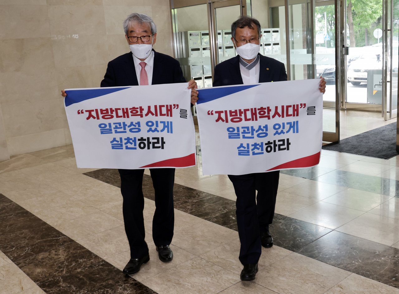 7일 오후 손팻말을 든 비수도권 대학 총장들이 박순애 교육부 장관과 반도체 학과 관련 간담회를 하기 위해 여의도 한국교육시설안전원에 들어가고 있다. 왼쪽부터 이우종 지역대학총장협의회장, 박맹수 전북지역 대학총장협의회 회장. 수도권 대학 반도체 관련학과 증원에 반대하는 비수도권 '7개 권역 대학 총장협의회 연합'은 이날 박순애 장관과 여의도에서 비공개 간담회를 했다. [연합]