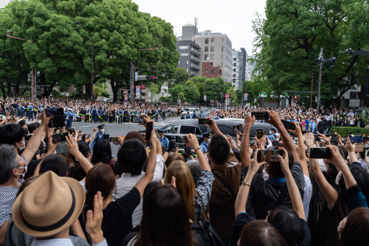 일본에서 코로나19 신규 확진자가 급격히 늘고 있다. 사진은 12일 도에서 아베 신조 전 총리 운구 차량이 지나는 것을 보기 위해 거리에 추모 인파가 몰려 있는 모습이다. [신화]
