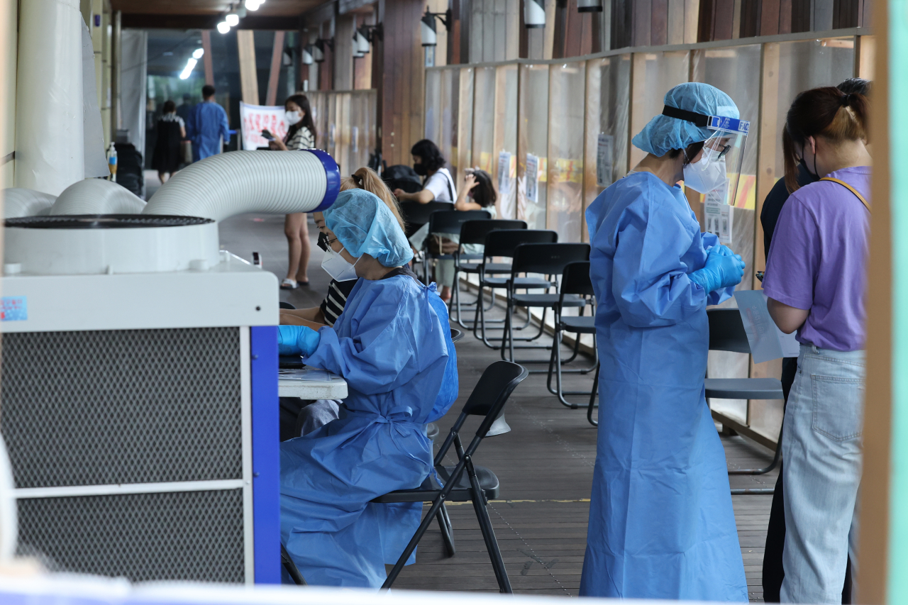 Health care workers conduct testing at an outdoors COVID-19 testing site in Songpa, southern Seoul, on July 8. (Yonhap)