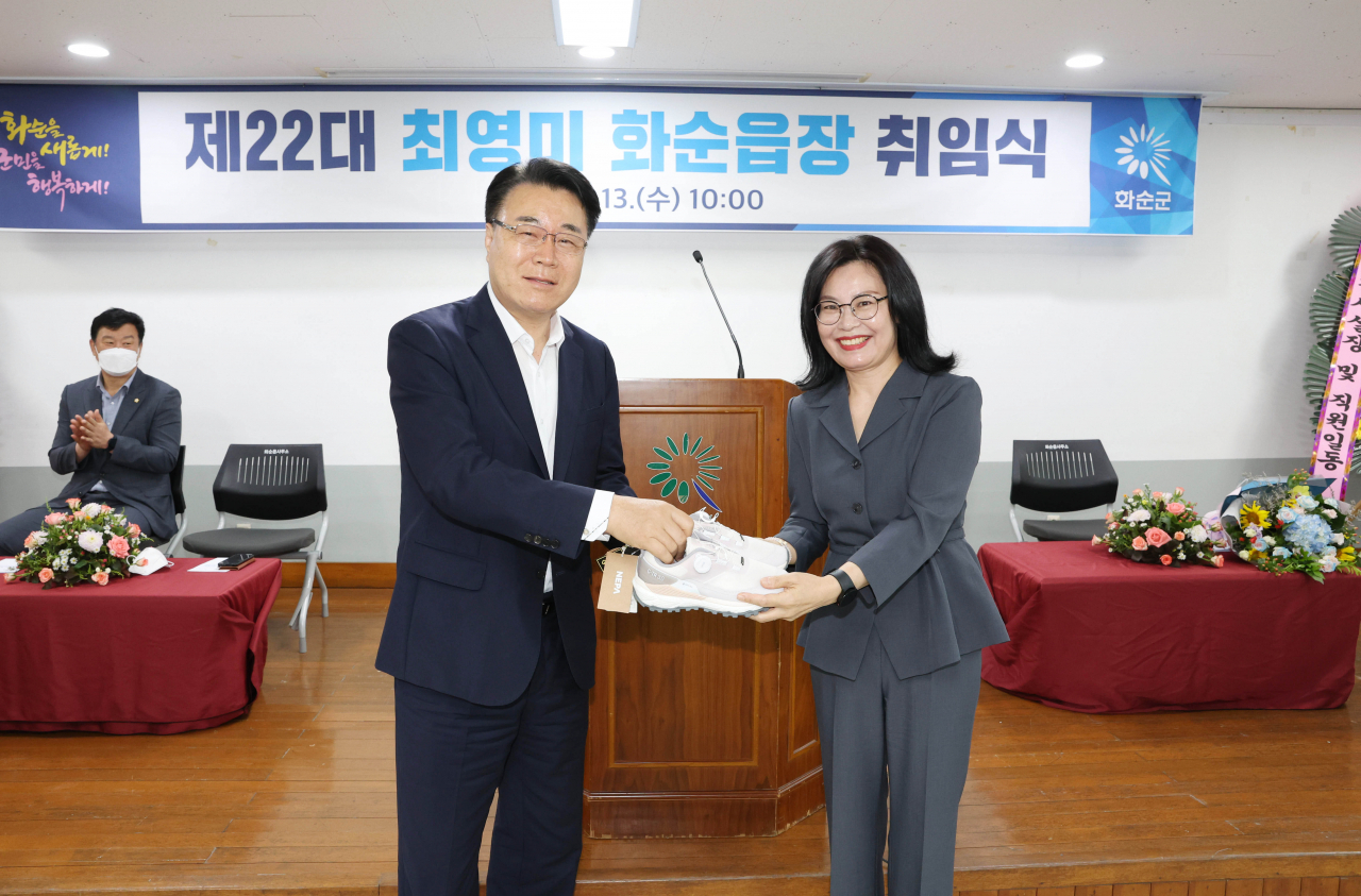 구복규군수가 최영미읍장에게 운동화를 선물하고 있다