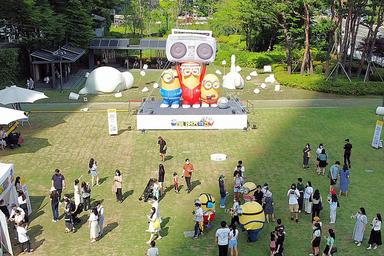 고객들이 ‘미니언즈크쥬'와 미니언즈 코스튬과 함께 사진을 촬영하고 있다. [롯데물산 제공]