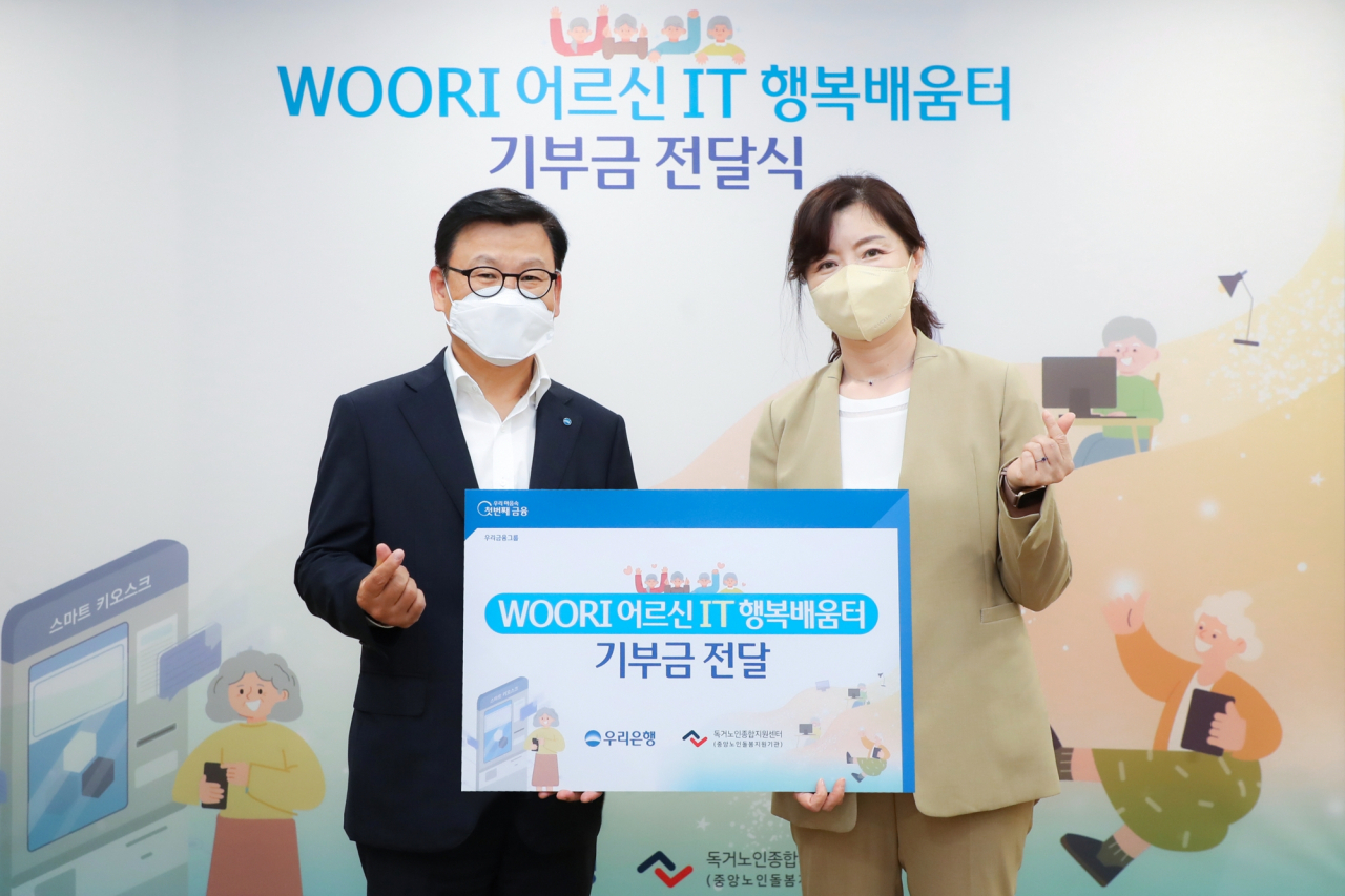 우리은행(은행장 이원덕)은 지난 13일 서울 중구 소재 우리은행 본점에서 'WOORI 어르신 IT 행복배움터' 기부금 전달식을 가졌다. 이원덕 우리은행장(왼쪽)과 김현미 독거노인종합지원센터 센터장이 기념촬영을 하고 있다.