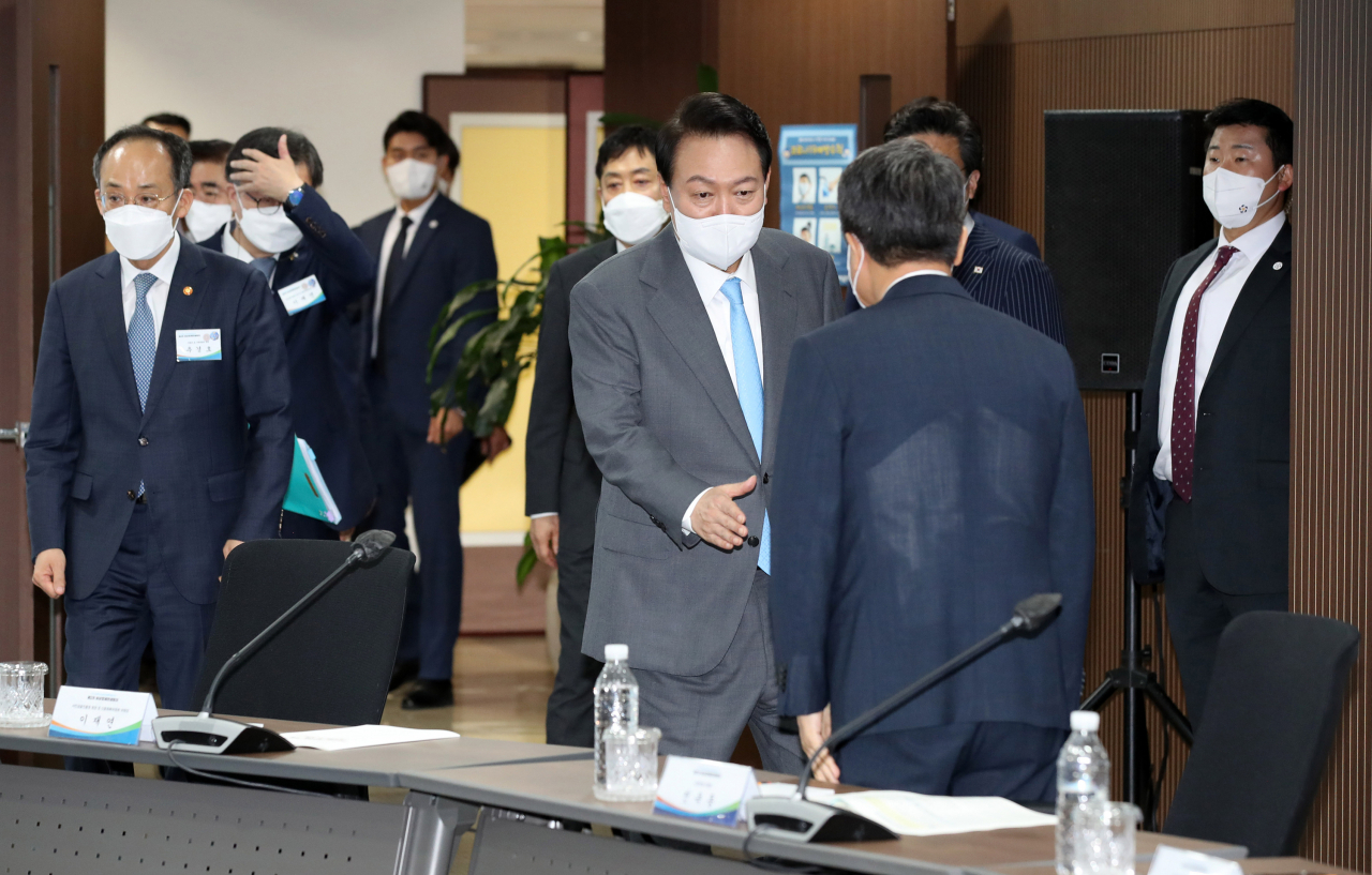 윤석열 대통령이 14일 오전 서울 중구 서민금융통합지원센터에서 열린 제2차 비상경제민생회의에서 참석자들과 악수하고 있다. [연합]