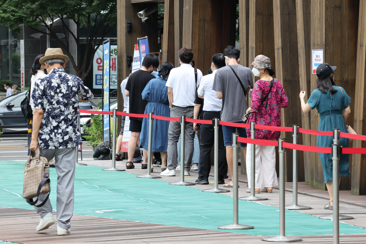 코로나19 신규 확진자 수가 3만9196명을 기록한 14일 오전 서울 송파구 보건소 선별검사소에서 시민들이 줄을 서서 검사 순서를 기다리고 있다. 연합뉴스