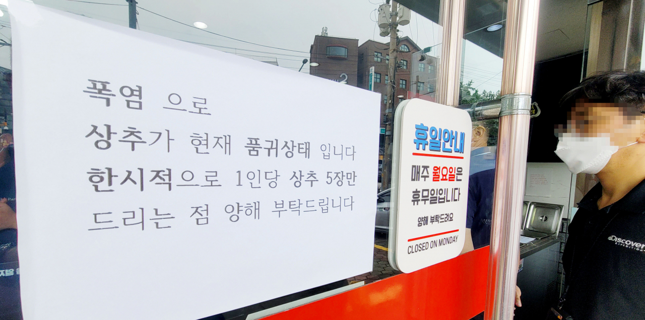 연일 지속되는 폭염으로 채소 공급이 어려움을 겪는 가운데 12일 오후 서울의 한 음식점에 상추를 1인당 5장만 제공한다는 내용의 안내문이 붙어 있다. [연합]