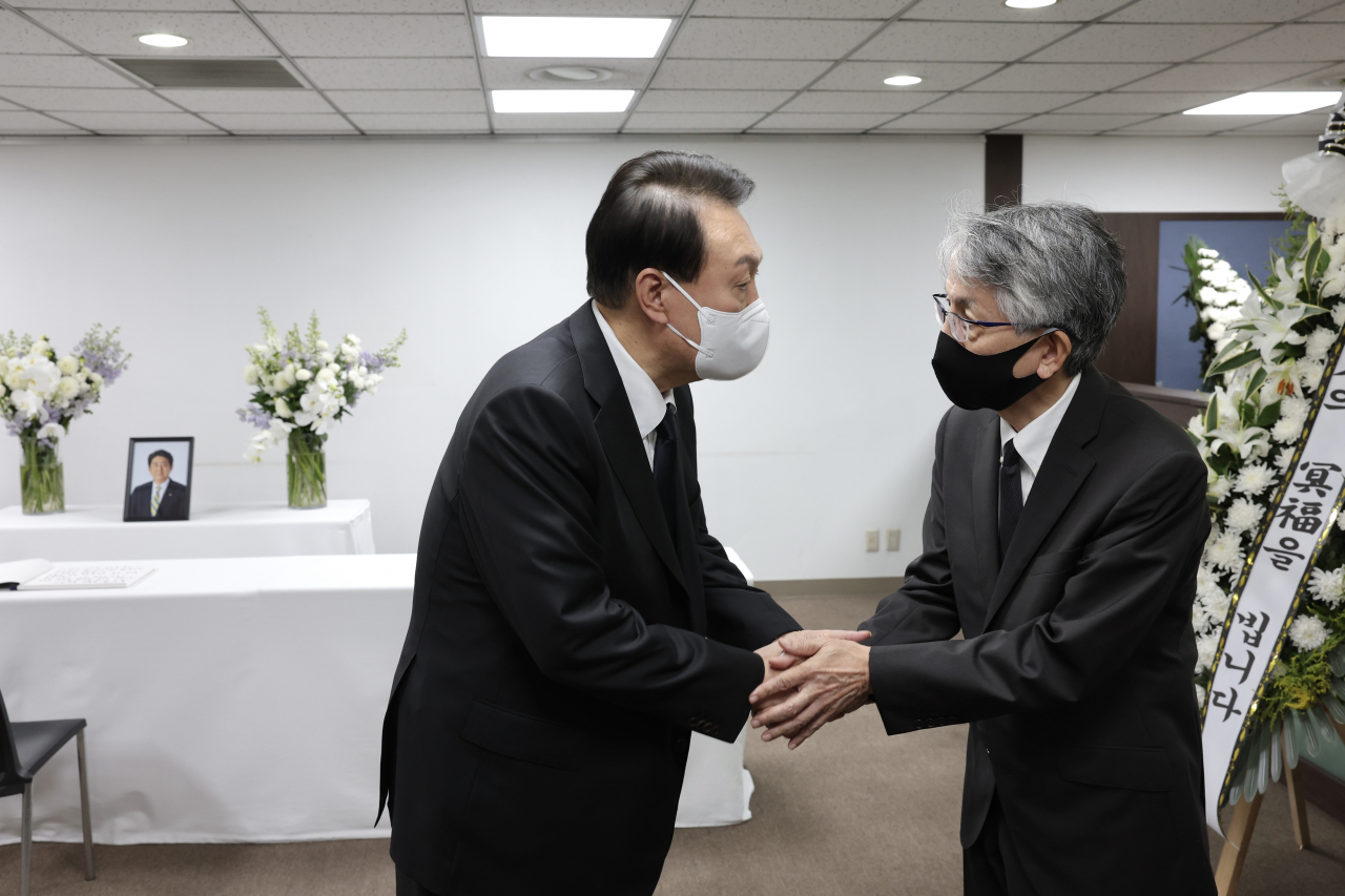 윤석열 대통령이 12일 오후 서울 종로구 주한일본대사관 공보문화원에 마련된 아베 신조 전 일본 총리 분향소를 찾아 조문록을 작성한 뒤 아이보시 고이치 주한 일본대사와 대화하고 있다. 연합뉴스