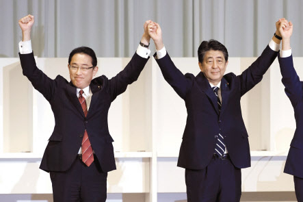 기시다 후미오(岸田文雄·왼쪽) 일본 총리와 아베 신조(安倍晋三) 전 일본 총리가 지난 2020년 9월 도쿄(東京) 자민당 중앙당사에서 열린 자민당 총재 선거에서 손을 잡고 함께 만세를 하고 있다. [AP]