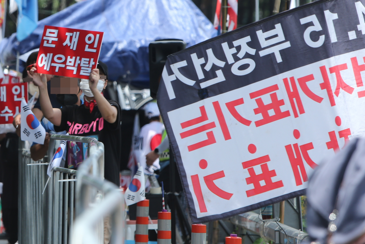 문재인 전 대통령에 반대하는 단체 회원들이 17일 낮 문재인 전 대통령 사저가 있는 경남 양산시 하북면 지산리 평산마을에 모여 문 전 대통령 수사, 전직 대통령 예우박탈 등을 주장하는 집회를 하고 있다. 반대단체 회원들이 지나가는 차량을 향해 문 전 대통령을 비난하는 피켓 등을 흔들고 있다. [연합]
