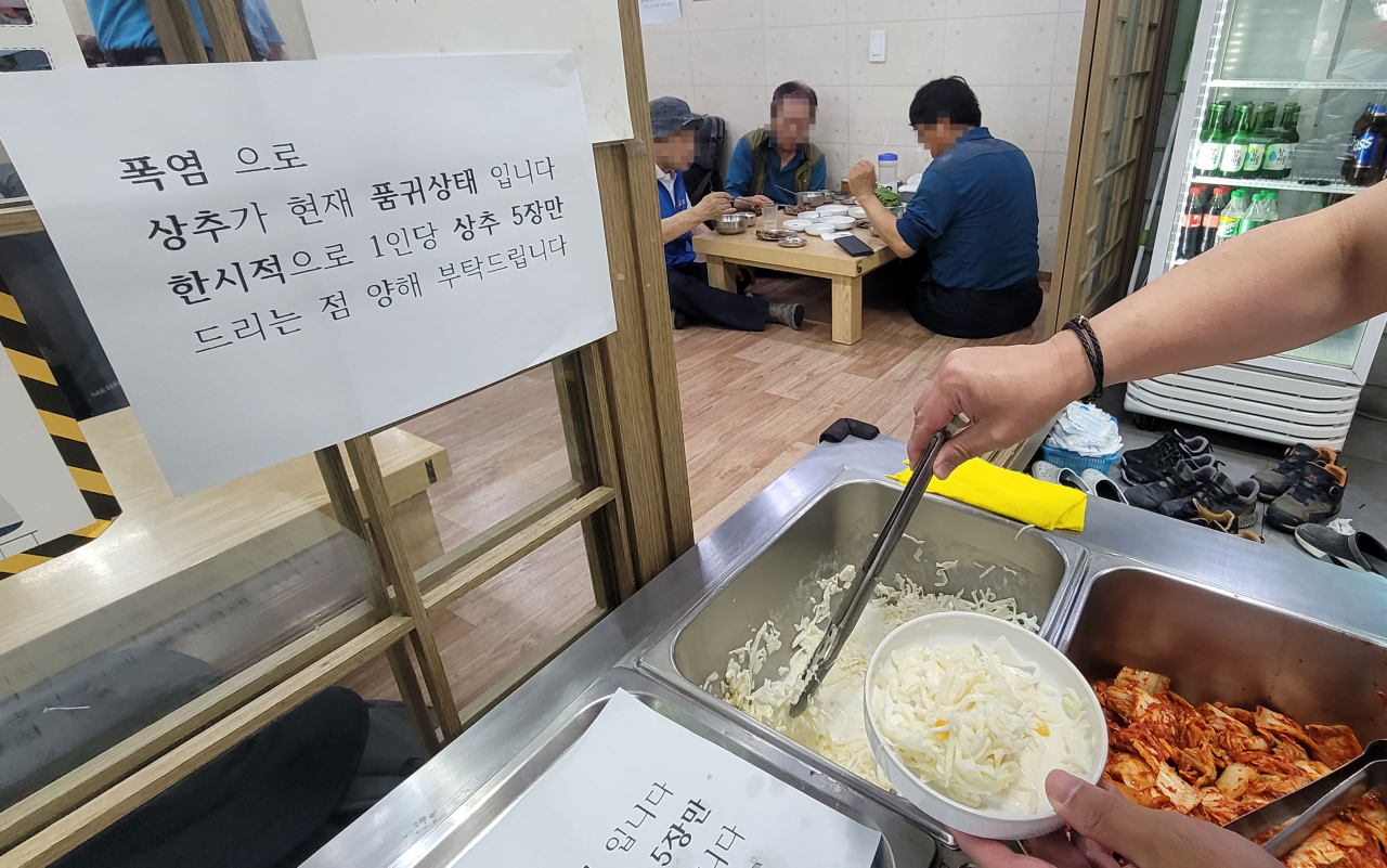 연일 지속되는 폭염으로 채소 공급이 어려움을 겪는 가운데 12일 오후 서울의 한 음식점에 상추를 1인당 5장만 제공한다는 내용의 안내문이 붙어 있다. [연합]