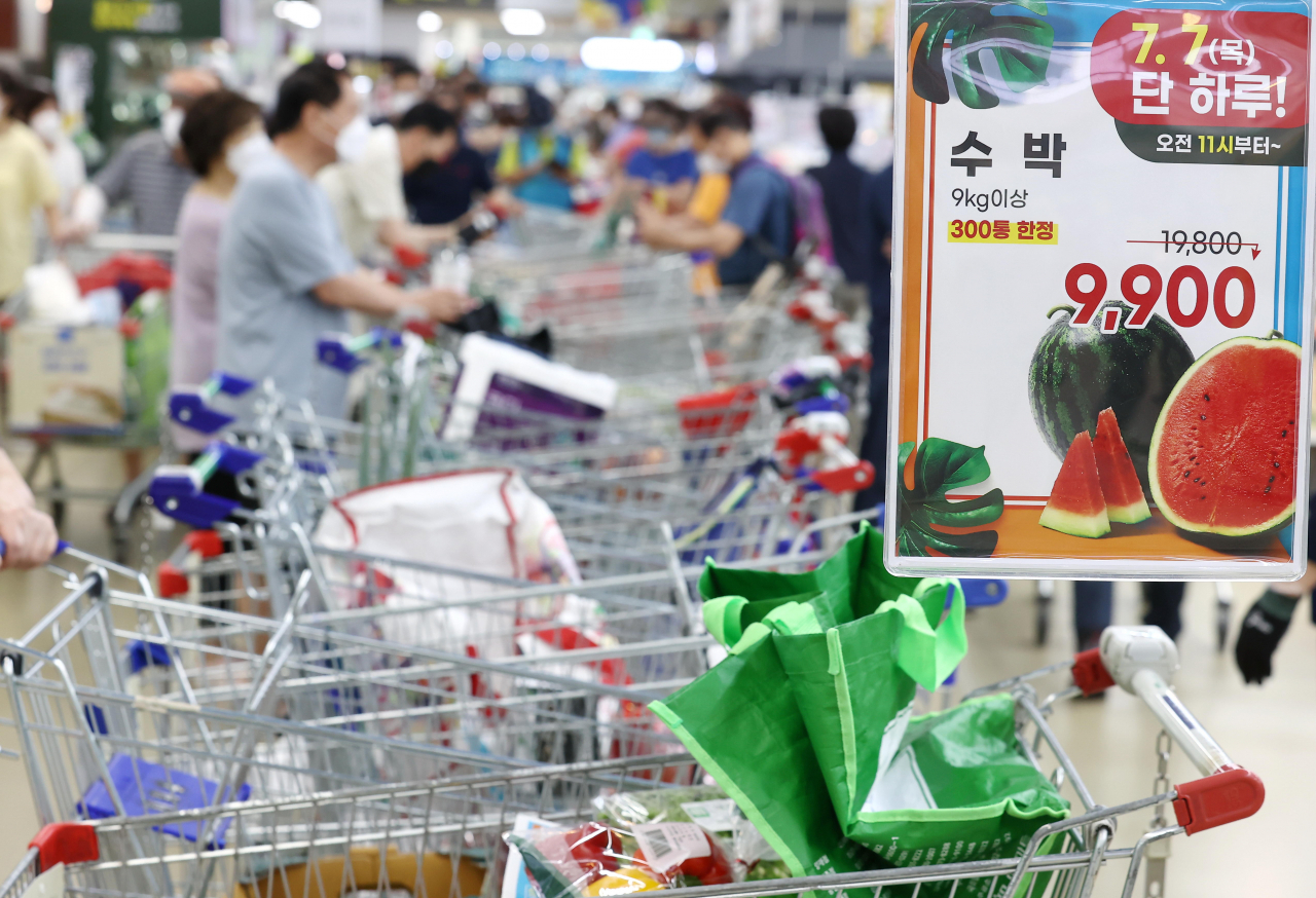 7일 오전 서울 하나로마트 양재점에서 시민이 300통 한정 특가로 판매되는 수박을 구입하기 위해 줄을 서고 있다. [연합]