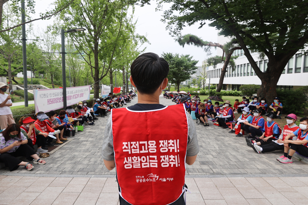 연세대학교 청소·경비노동자들이 지난 12일 서울 서대문구 연세대학교 백양관 앞에서 임금인상과 샤워실 설치 등을 주장하며 집회를 하고 있다. [연합]