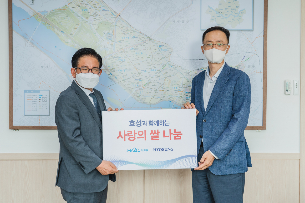 18일 마포구 취약계층을 위해 20㎏짜리 백미 500포대를 전달하고 박강수(왼쪽) 마포구청장과 이정원 효성 커뮤니케이션실장이 기념촬영을 하고 있다. [효성 제공]